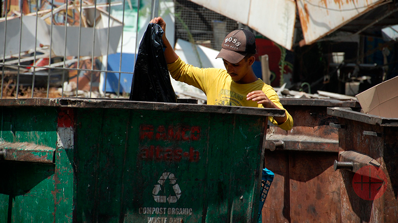 personas buscan en la basura